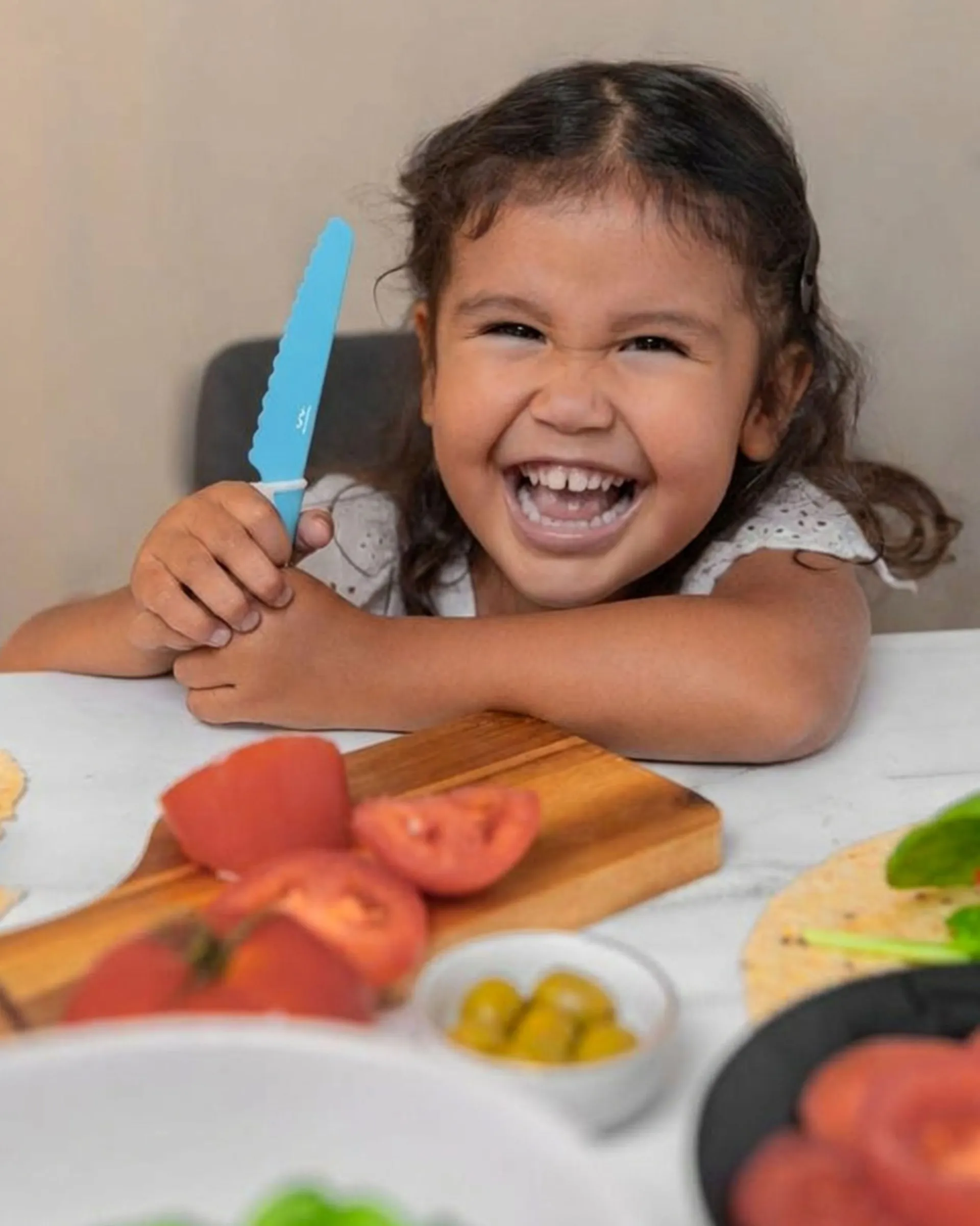 Smiling child using a Frozen Blue KiddiKutter