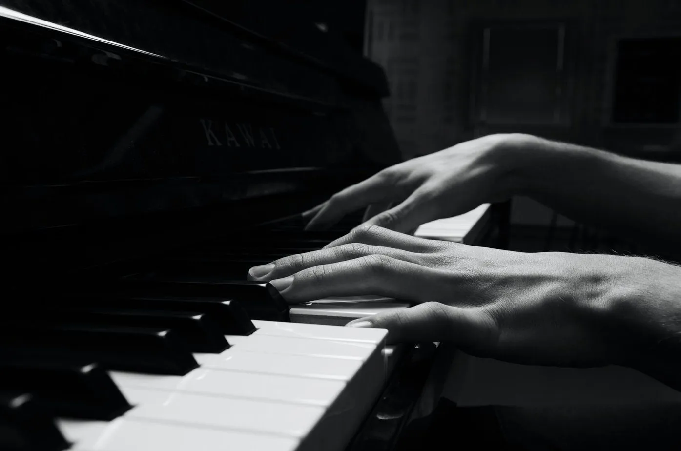 Hands playing a grand piano