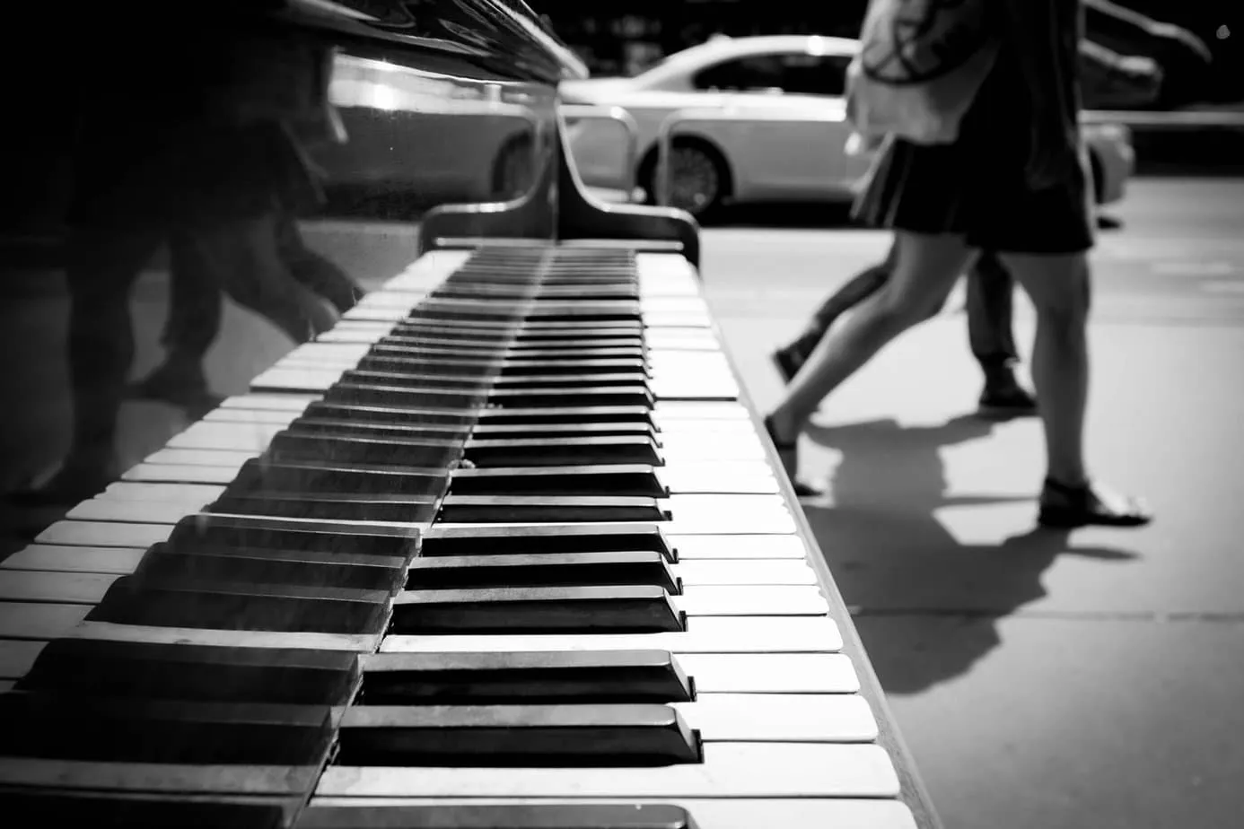 People walking past a grand piano