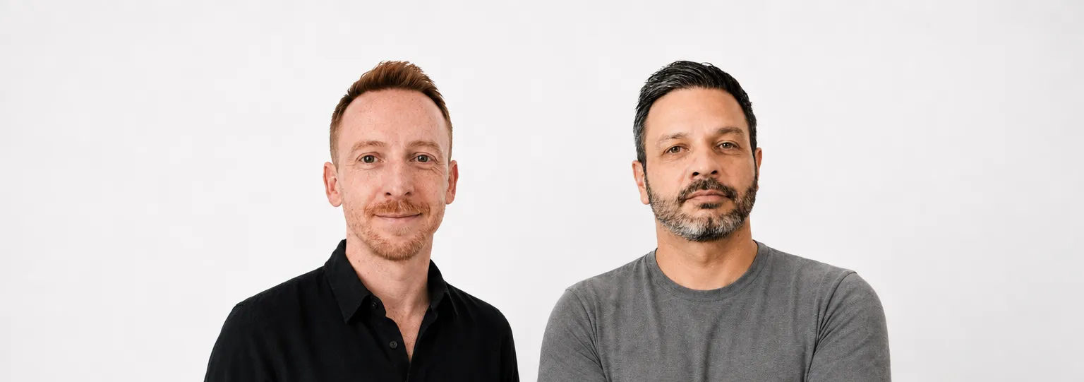 Two men posing against light gray background