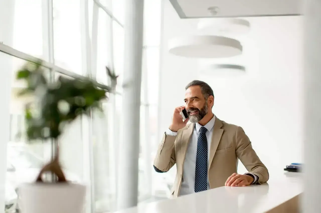 Empresario de mediana edad con teléfono móvil x1280
