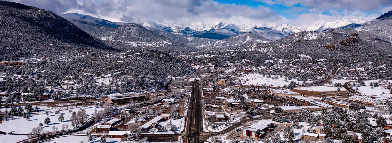 Estes Park snowshoeing trail through snow-covered pines with mountain backdrop