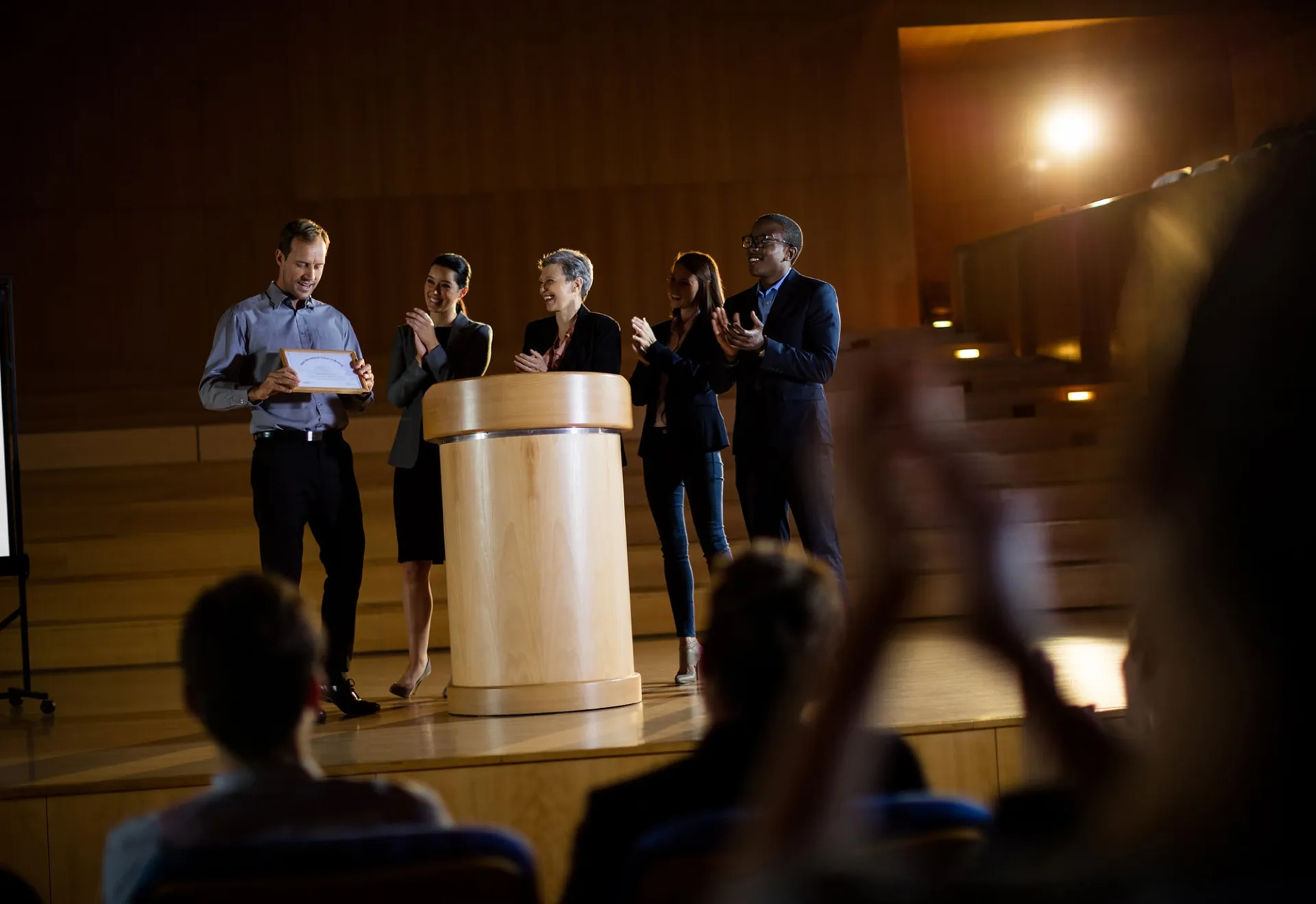 Male business executive receiving award at conference center