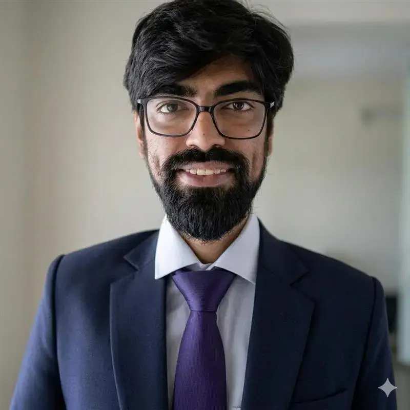 Professional headshot of Abhinav Saini wearing a business suit, glasses, and purple tie