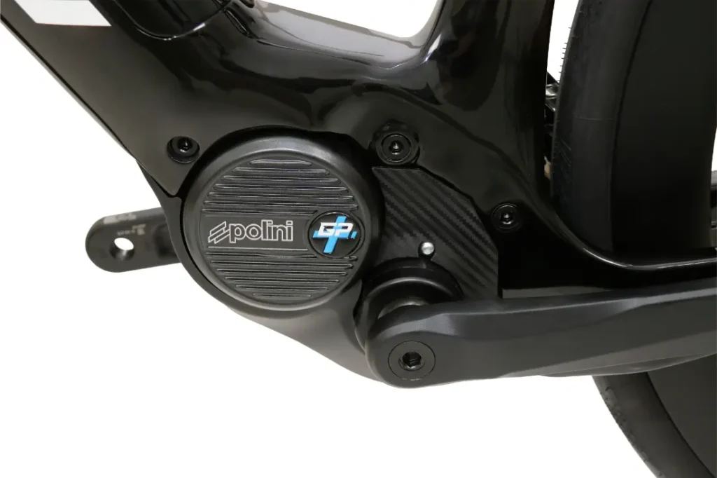 Primer plano de un motor para bicicleta eléctrica Polini E-P3 montado en un cuadro de bicicleta negro, en el que se aprecian los tornillos y parte del brazo de la biela.