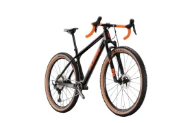 Una bicicleta de gravel negra y naranja con manillar de carretera y neumáticos de flanco marrón claro, representada sobre un fondo blanco.