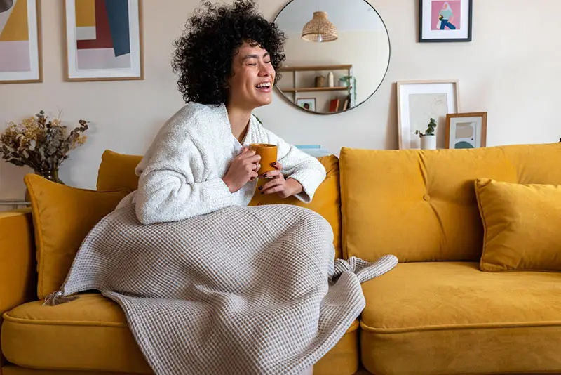 A woman relaxing on sofa in comfort with blanket