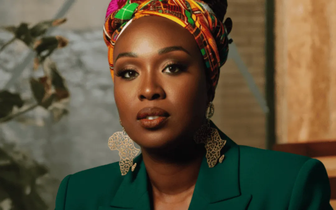 Portrait of a woman in a green blazer with colorful headwrap and large earrings