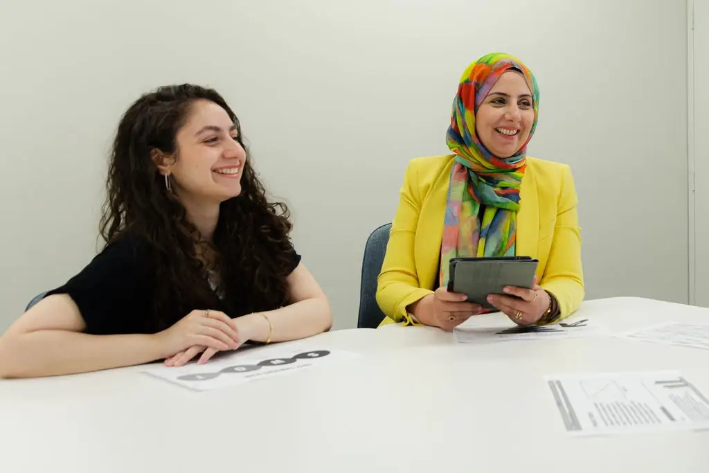 Two digital marketing professionals collaborating at desk with tablet and strategy documents