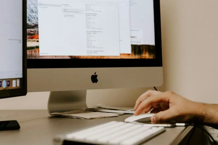 Person conducting a local SEO audit on an Apple computer in Perth office, improving SEO strategy with notes and analytics on screen.