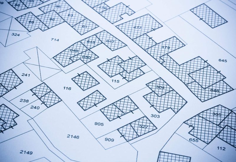 Imaginary cadastral map with buildings, land parcel and vacant plot printed on pape