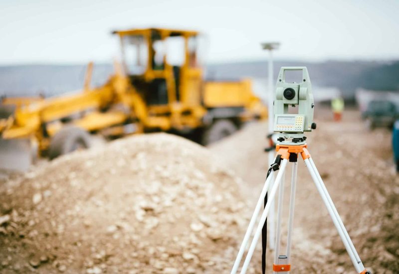 Surveyor equipment GPS system or theodolite outdoors at highway construction site.