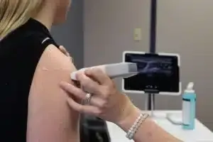 Pain management doctor examining a patient's shoulder for rotator cuff pain in Tyler TX