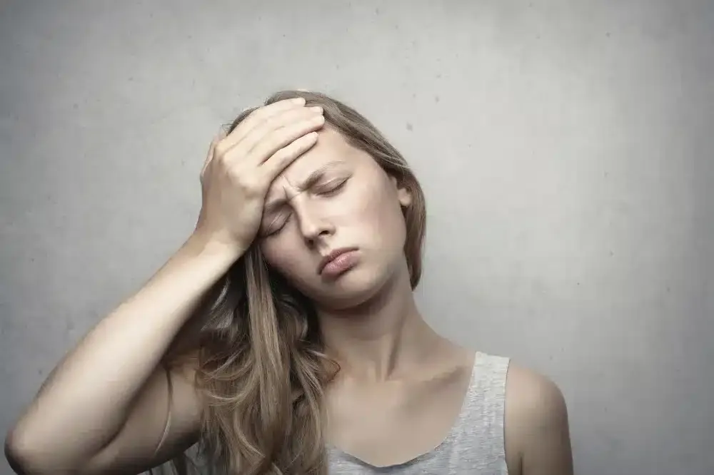 Botox for Chronic Migraines in Grand Prairie, TX | Same-Week Consults 3 Woman holding her head in pain from chronic tension headache needing treatment