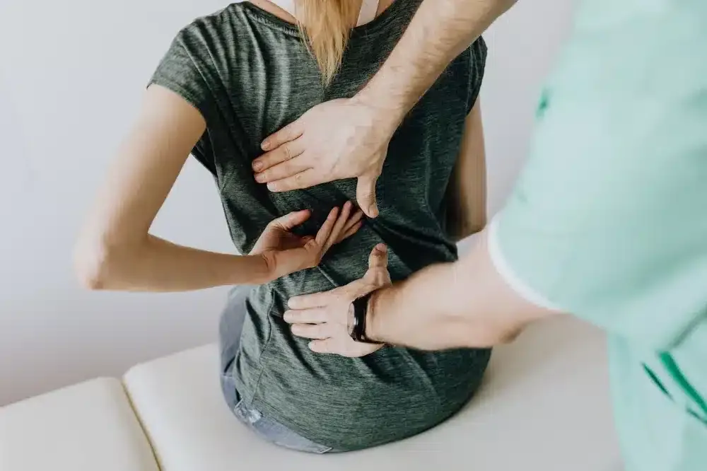 Lumbar Epidural Steroid Injection in Longview, TX | Non-Surgical Options 1 Man holding lower back in pain from herniated disc while sitting at desk