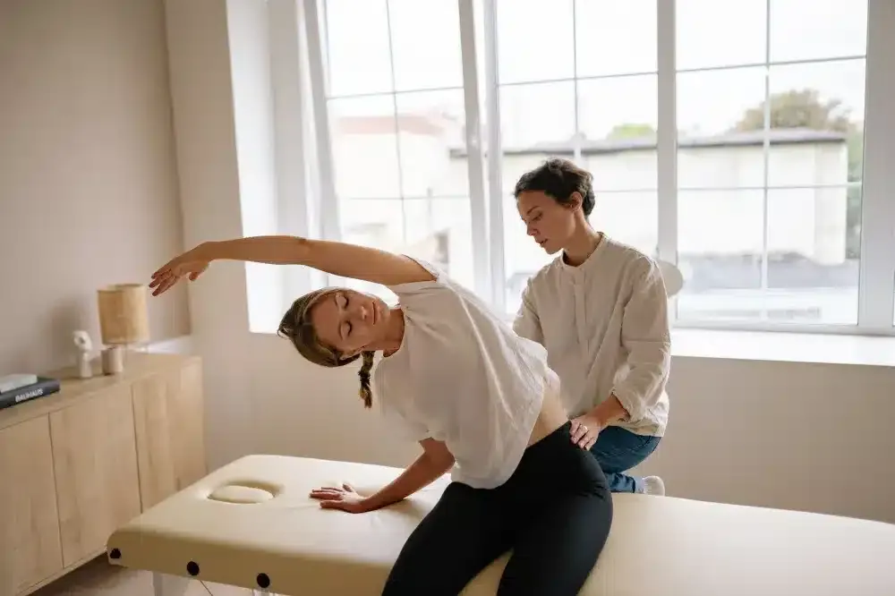 Trigger Point Injections in Plano, TX | Same-Week Consults 3 Physical therapist guiding a patient through therapeutic stretching exercises for muscle pain relief