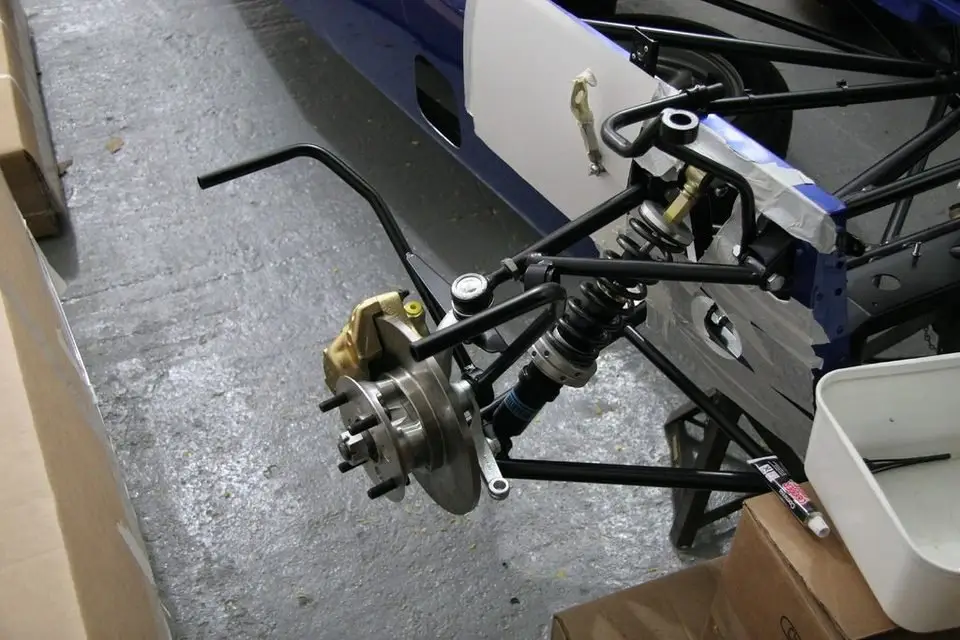 Front suspension assembly with upper and lower control arms attached to the wheel hub