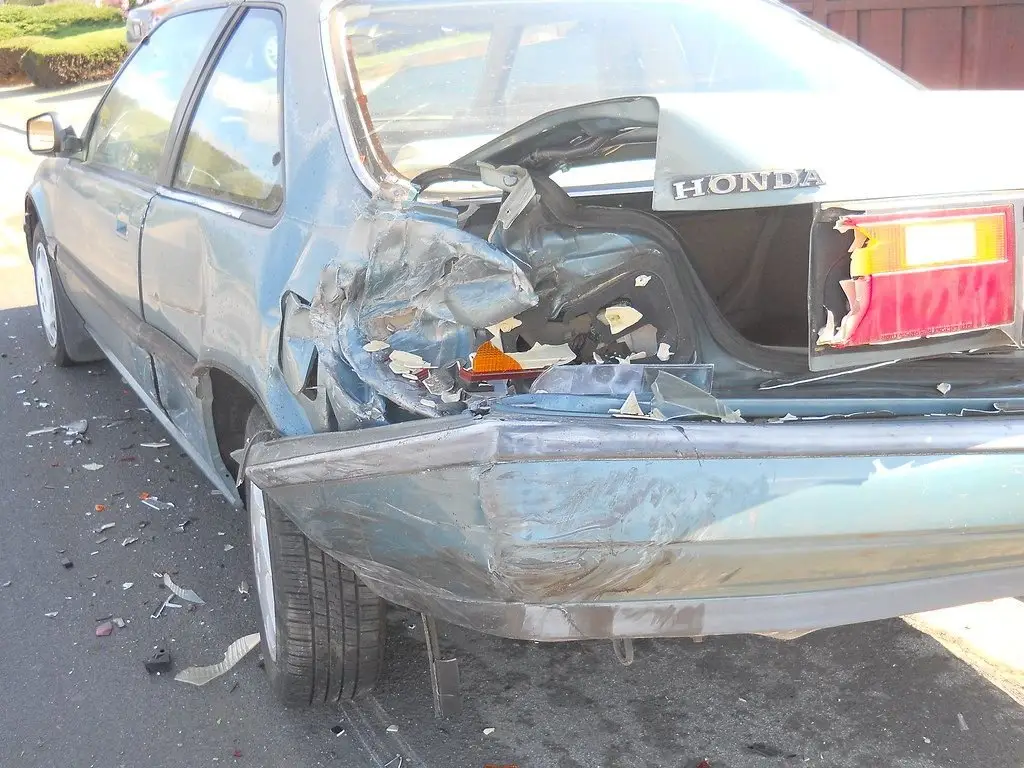 Totaled sedan with a crushed rear end after a crash, the situation where gap insurance and negative equity matter