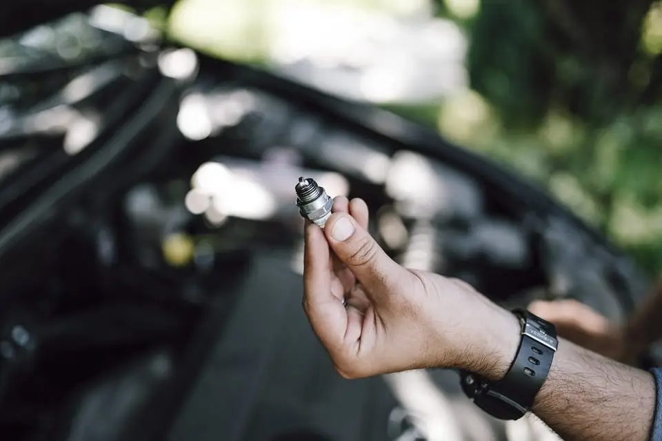 Mechanic holding a fuel injector removed from an engine