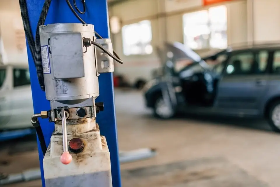 Car raised on a shop lift, where oil pan gasket work is done