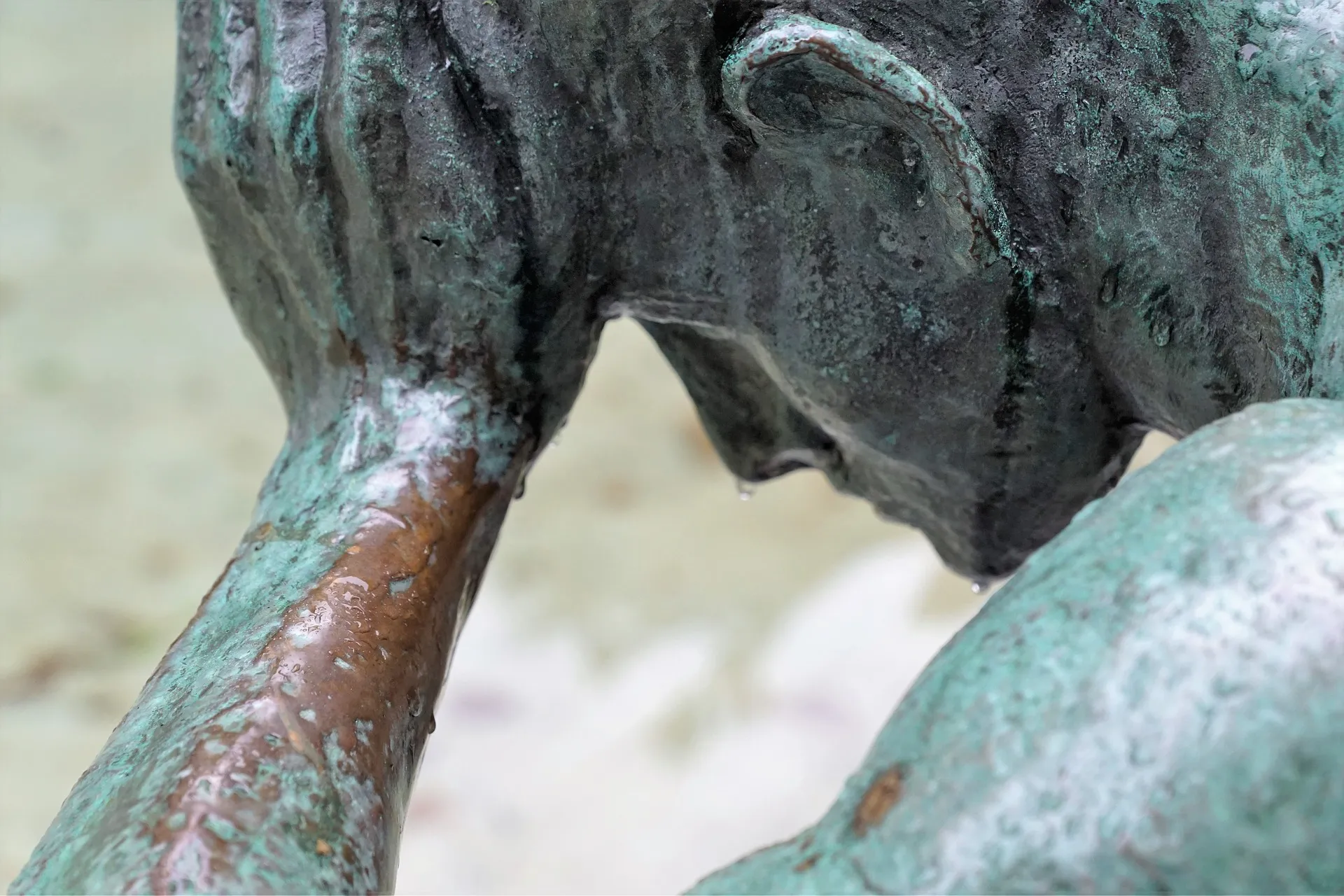 Nahaufnahme einer verwitterten Bronzestatue, die eine Person zeigt, die ihren Kopf auf die Hand stützt und damit eine kontemplative Stimmung hervorruft, die an die Selbstreflexion erinnert, die in der systemischen Therapie häufig untersucht wird.