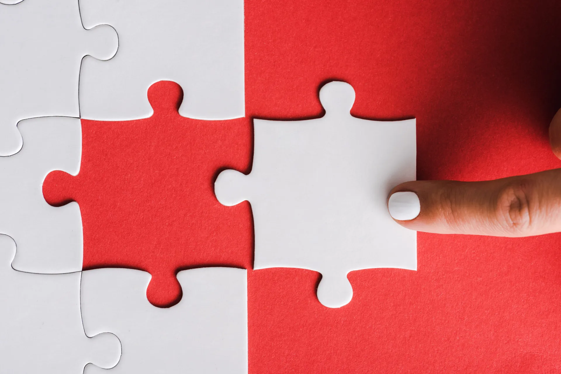 Weiße Puzzleteile auf rotem Grund