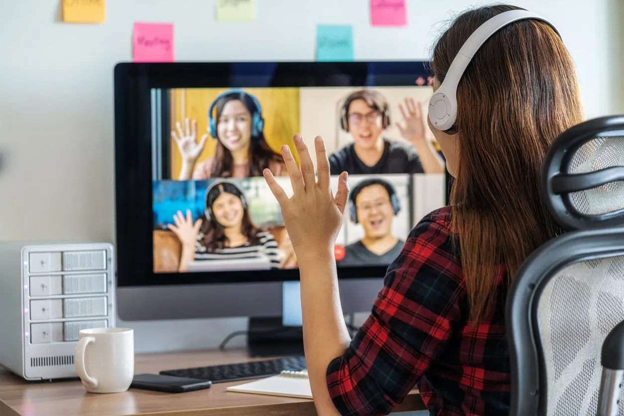Rear View of Asian Business woman say hello with teamwork colleague in video conference Rear View of Asian Business woman say hello with teamwork colleague in video conference
