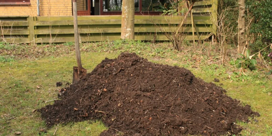 Tas de compost vรฉgรฉtal dans un coin de jardin.