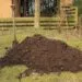 Tas de compost vรฉgรฉtal dans un coin de jardin.