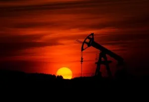 Silhouette of an oil pumpjack against a vibrant orange sunset sky, basking in the glow much like custom magnetic drive pump solutions that elevate innovation with precision and efficiency.