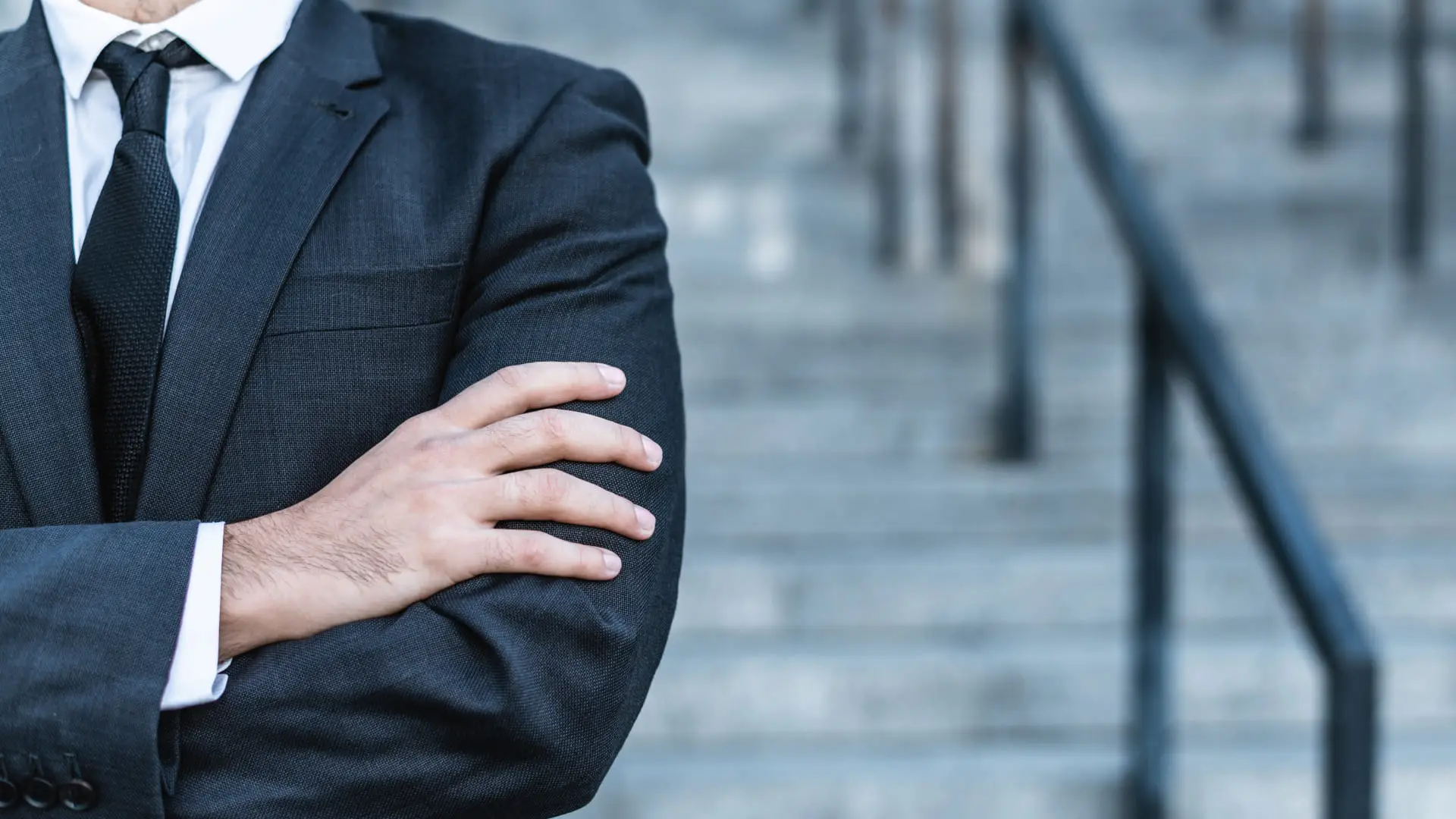Businessman standing confidently with arms crossed.