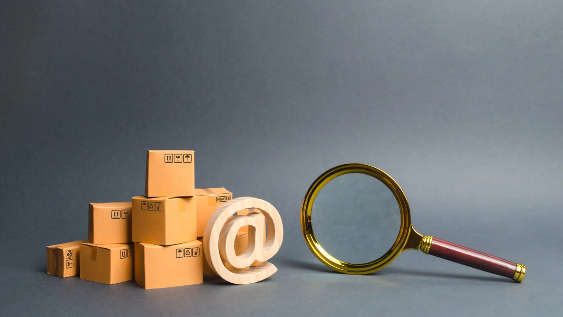 Packages with at symbol and magnifying glass representing online business search