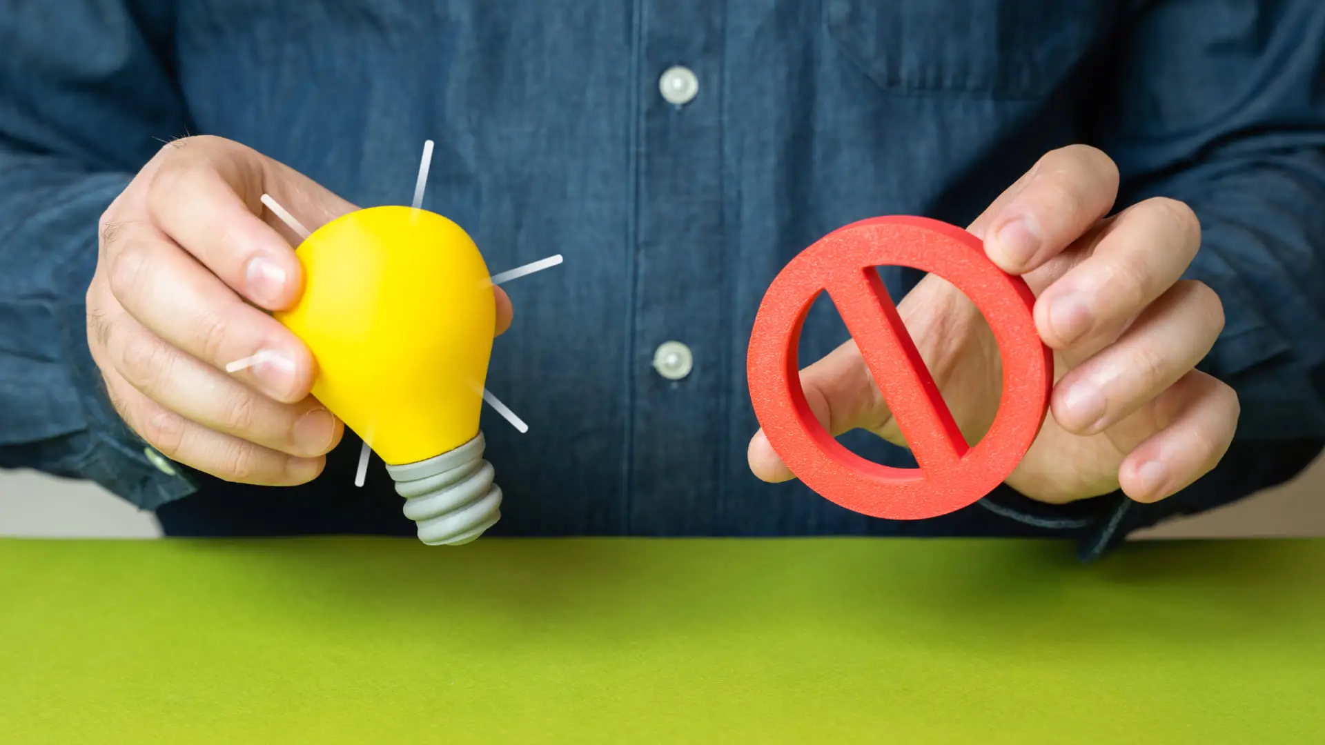 Person holding a light bulb and prohibition sign representing rejected ideas