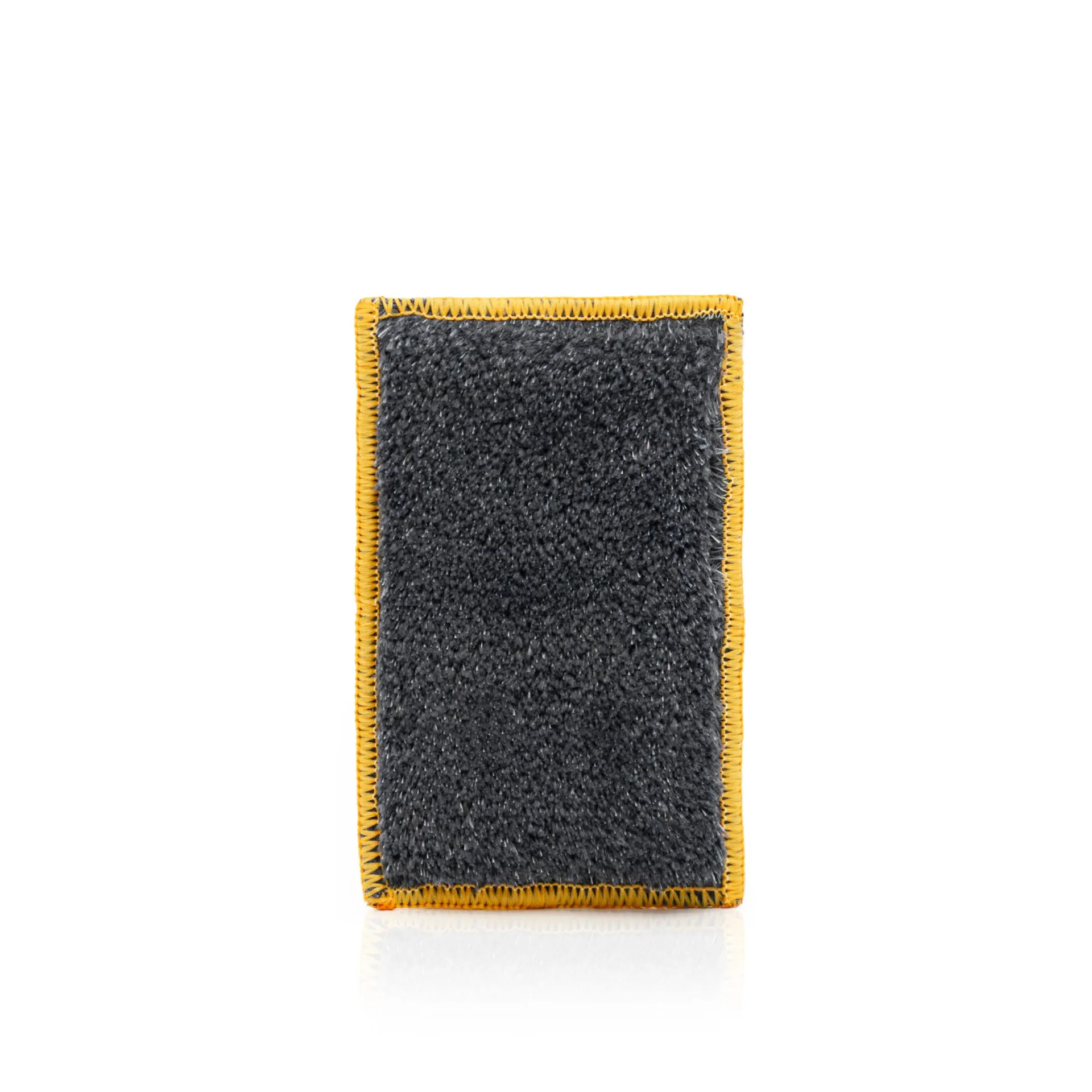 Rectangular gray cleaning sponge with yellow edges placed on a white background, showcasing its color and shape.