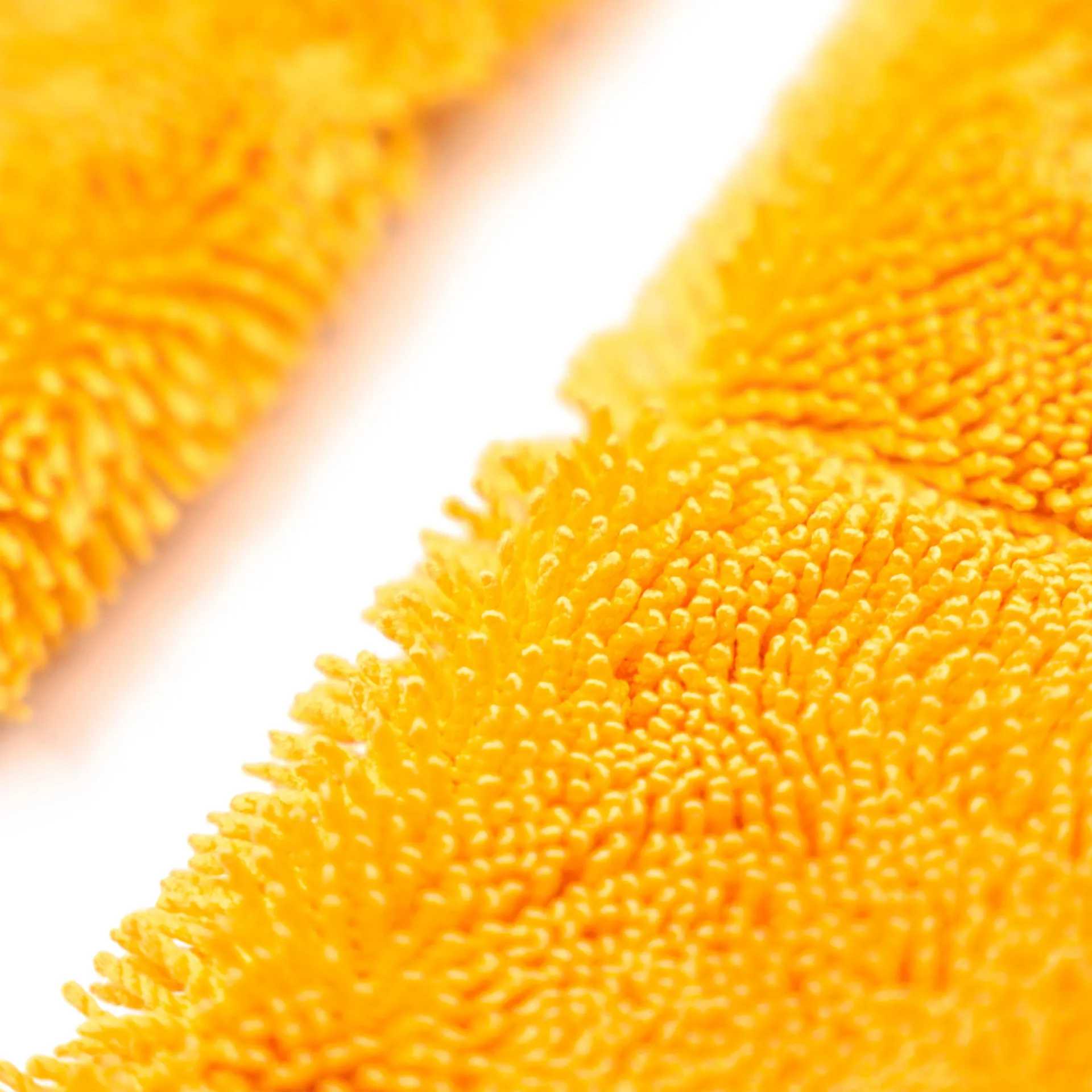 Two bright yellow microfiber towels with densely packed, soft fibers for car detailing on a white background.