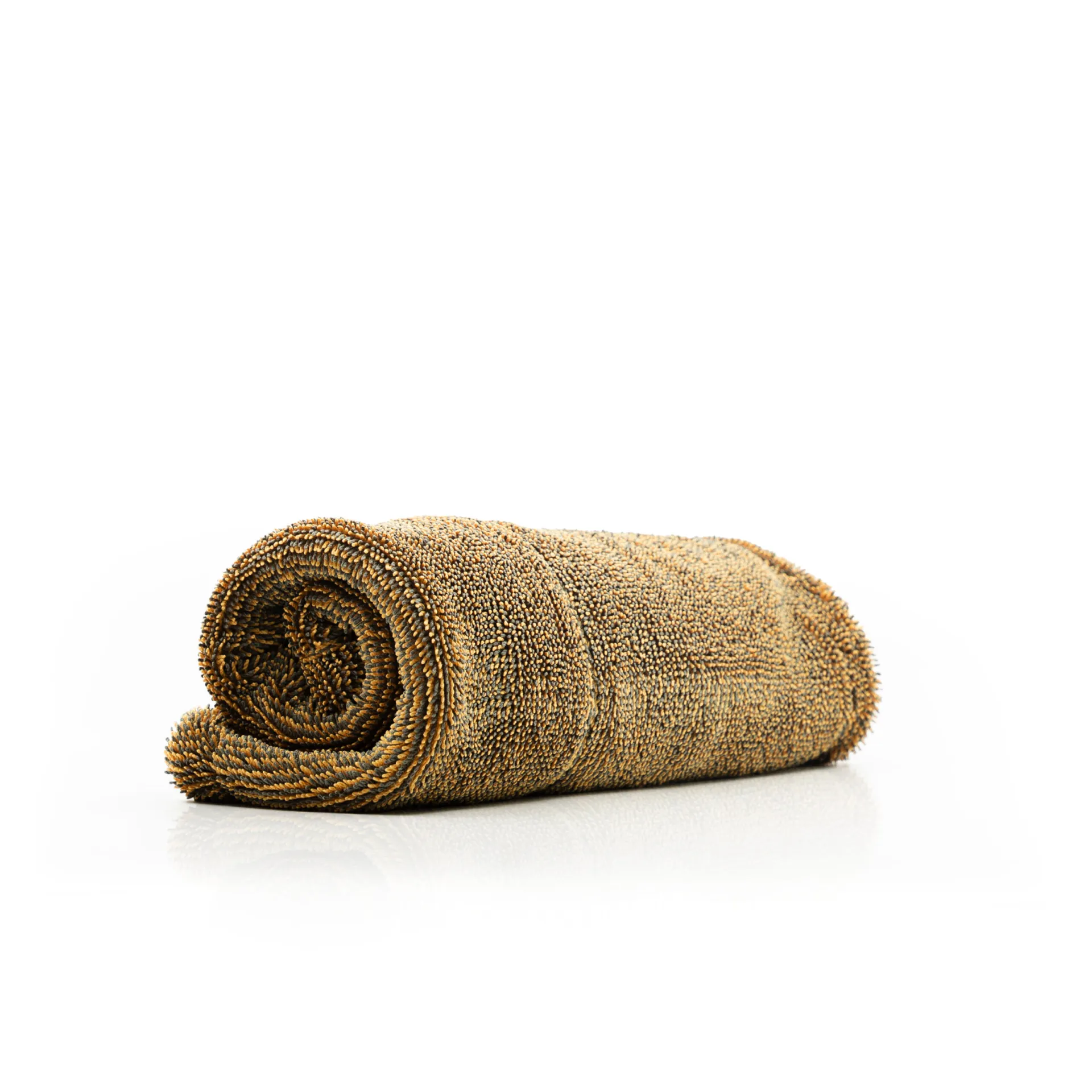 A brown microfiber towel rolled up neatly on a white surface against a plain white background.