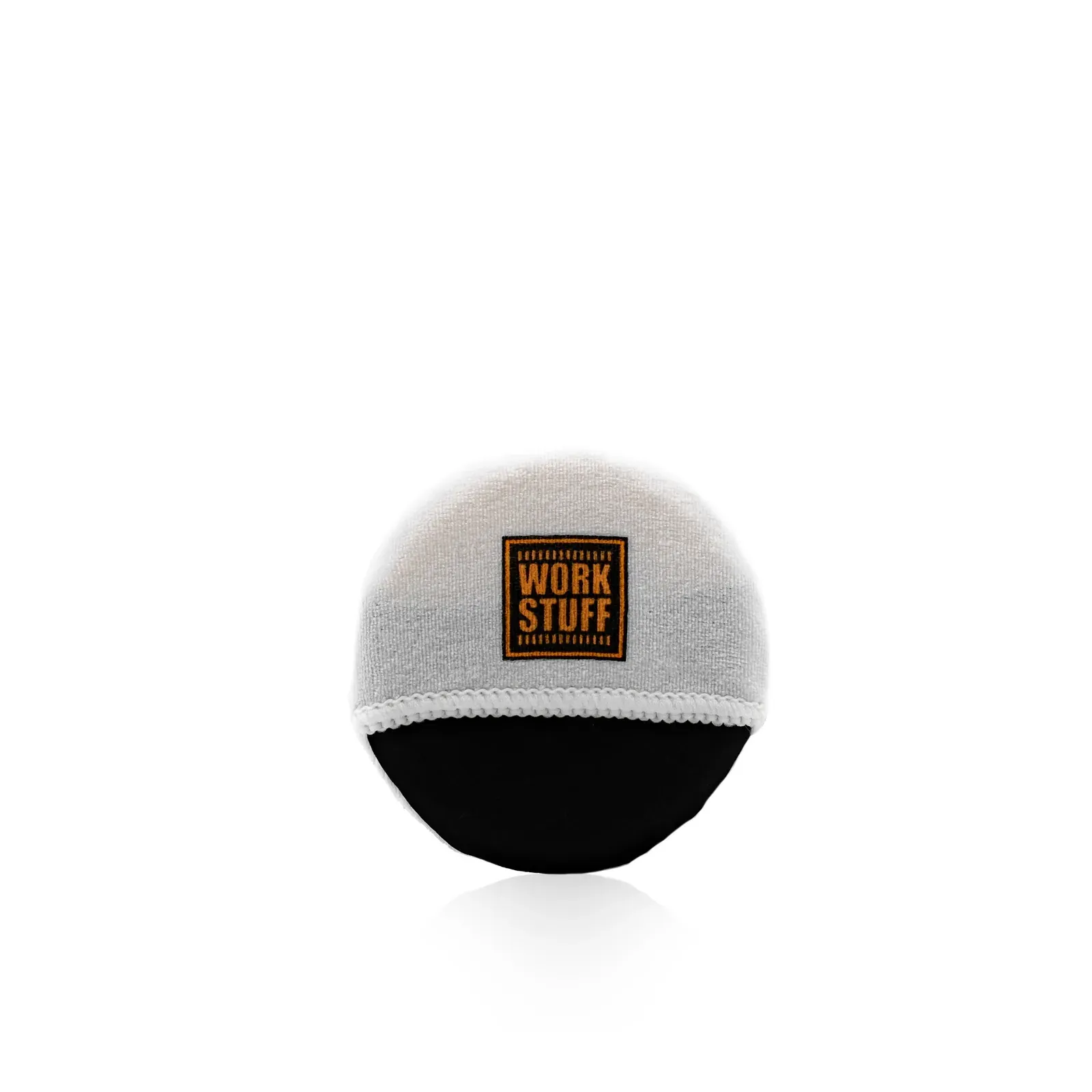 Una almohadilla aplicadora redonda con la base negra y la parte superior blanca, con una etiqueta cuadrada de color naranja en la que se lee «Work Stuff» en negro sobre fondo blanco.