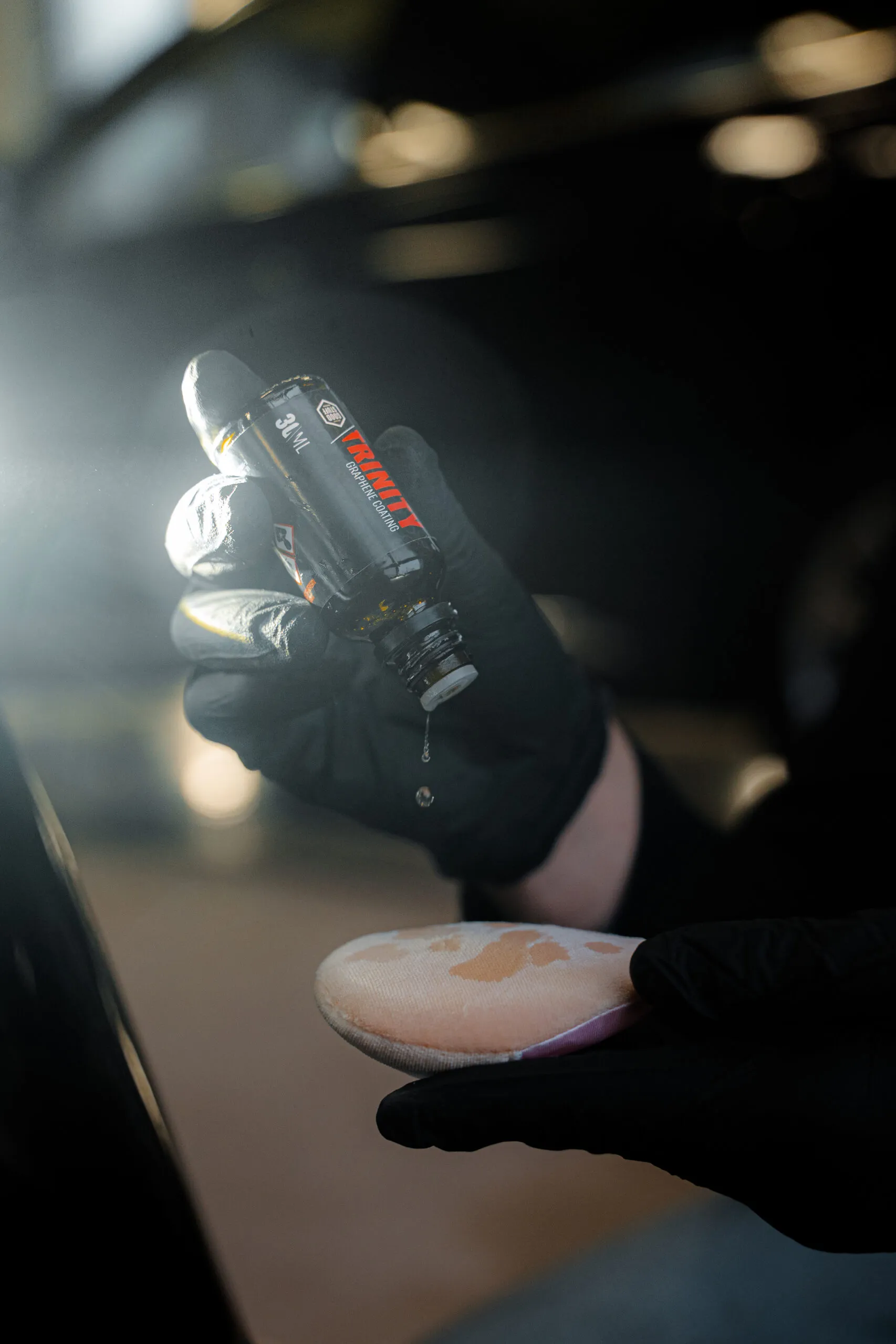 Trinity graphene coating drops being applied to a microfiber applicator pad