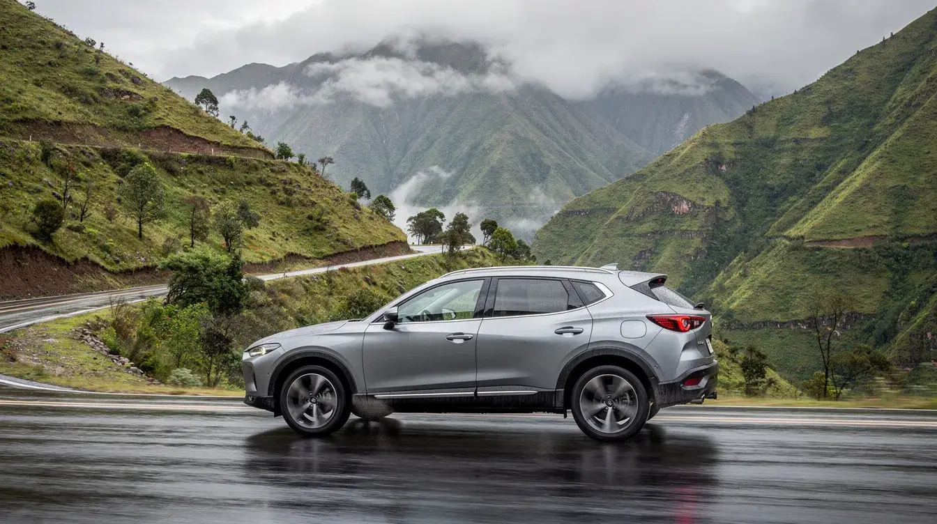Un SUV plateado circula por una carretera de montaña, rodeado de un vibrante paisaje verde andino que resalta la belleza natural de Ecuador. Esta imagen evoca la experiencia de un viaje en auto, ideal para explorar las rutas desde el aeropuerto internacional de Quito.