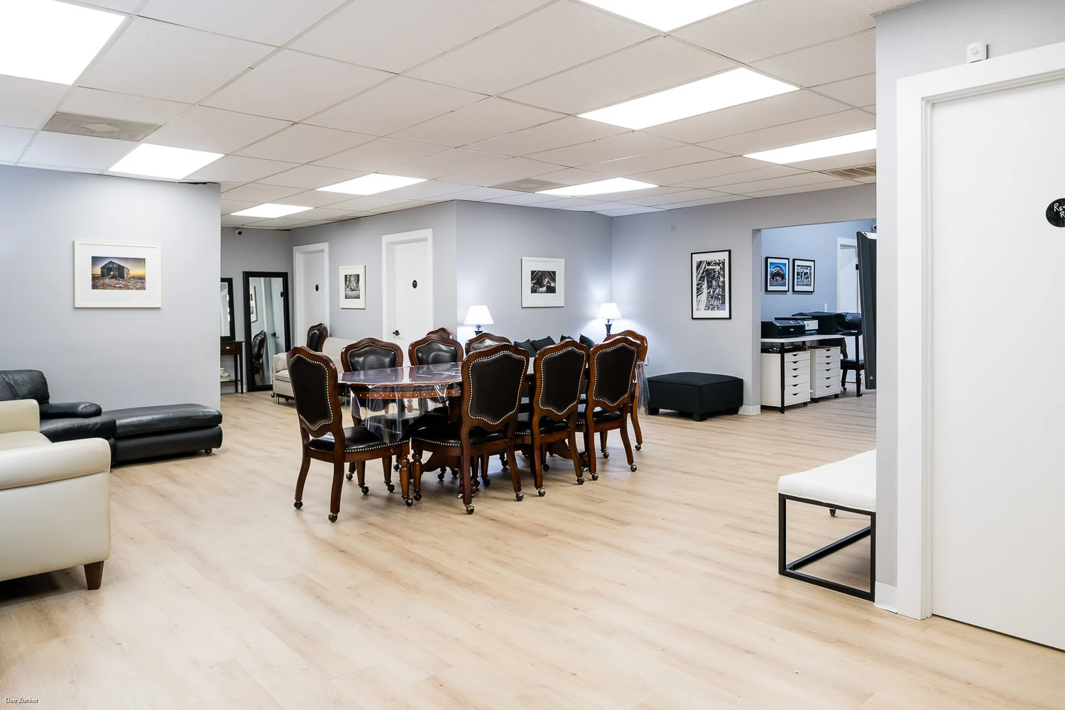 Wide view of the West Loop Studio client lounge, featuring comfortable seating, a conference area, and access to private restrooms.