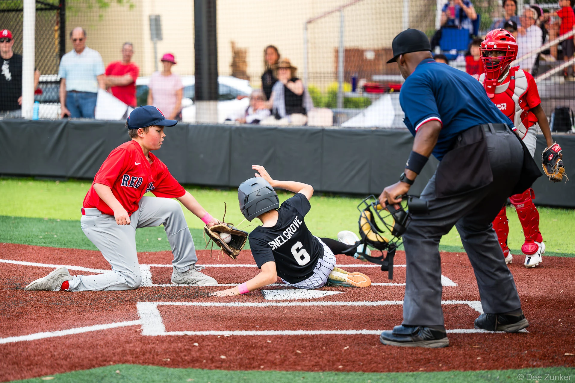 Red Sox fielder tags out White Sox player number 6 Snelgrove sliding into home plate at Bellaire Little League American League game.