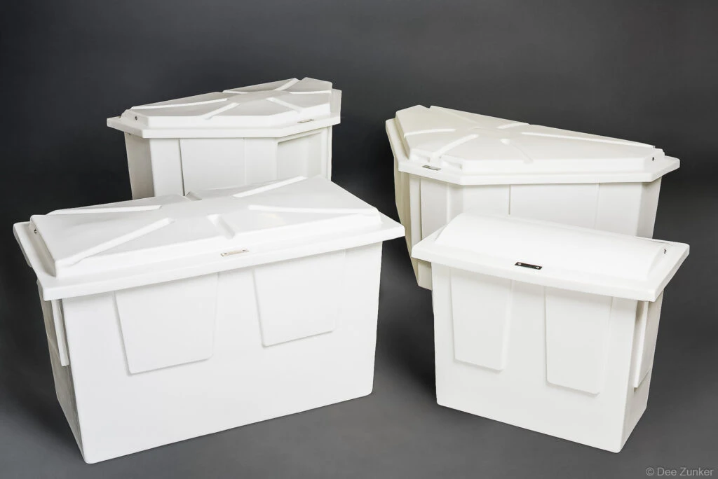 Four white polyethylene marine storage boxes with lids, varying sizes, arranged on gray background, Houston product photography.