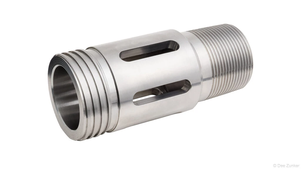 CNC-machined stainless steel drilling tool with threaded end and slotted ports, shot on white background for industrial product photography.