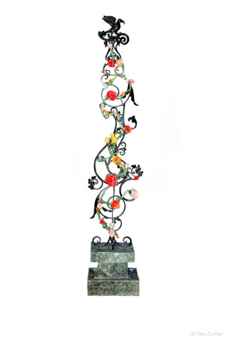 Wrought iron sculptural column with colorful painted roses and black eagle finial mounted on green marble tiered base, Houston product photography.