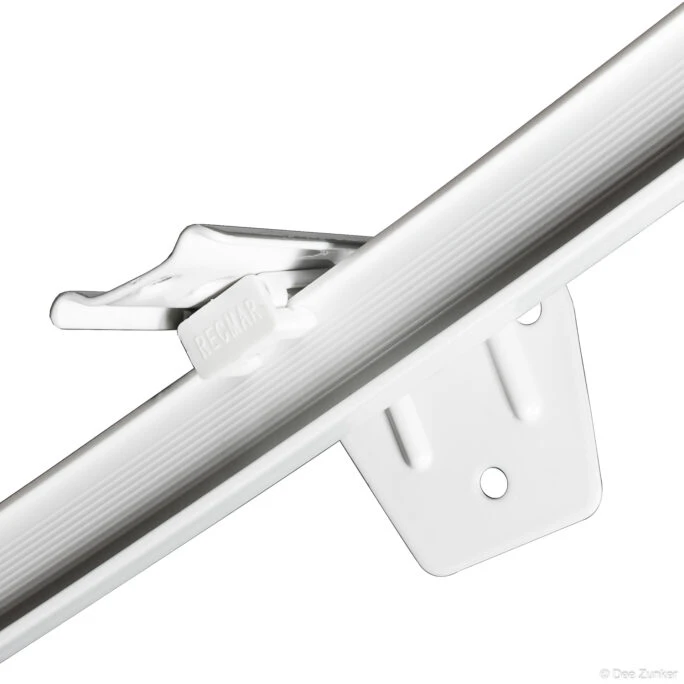 Close-up product photo of a white plastic industrial rail mounting bracket and clip on white background, Houston commercial photography.