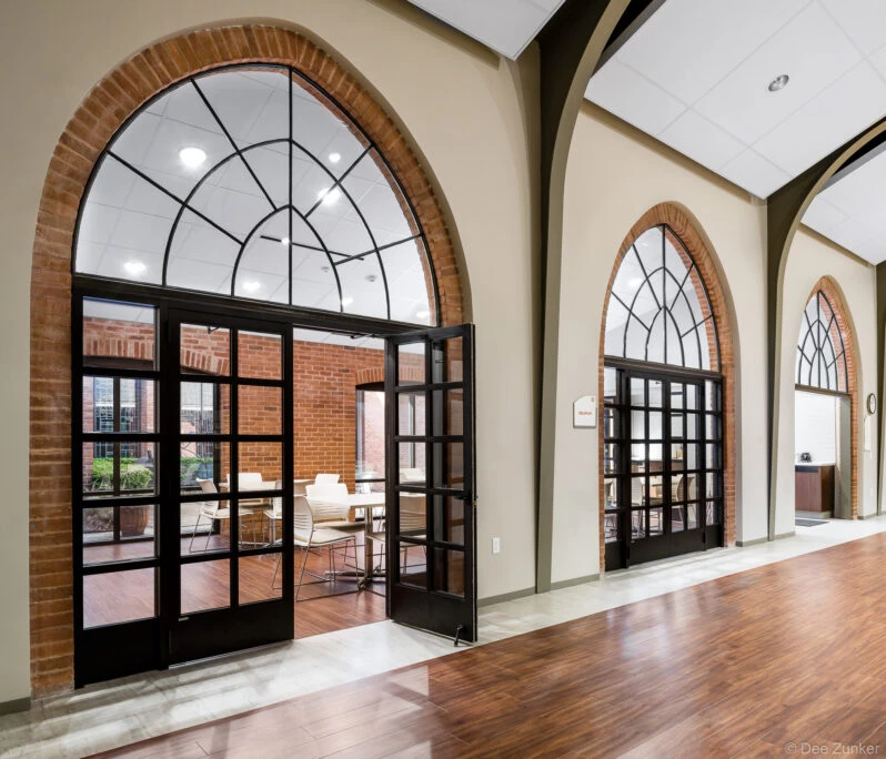 Architectural photo of the Calvary Episcopal Church community center. Glass doors for meeting rooms are framed by elegant architectural arches.