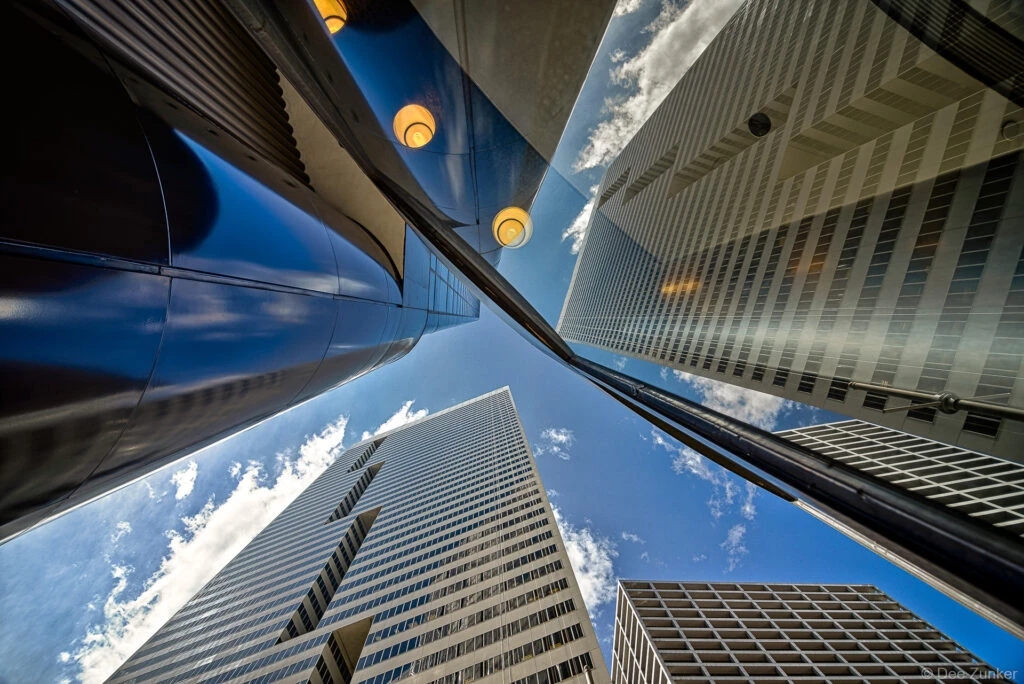 The First City Tower (circa 1981) reflects in the 2 Houston Center lobby. Those indentions in the First City Building are supposed to resemble “F’s”. Photo by Houston Architectural Photographer Dee Zunker