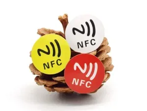 Три етикети на NFC во жолта боја, Бело, и црвените се ставаат на пинеконе.