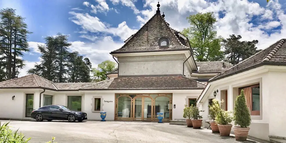 Luxury Montreux apartment rental with elegant tiled roof, arched doors, lush greenery, Alps views—GuestLee Swiss property. | GuestLee luxury rental Switzerland