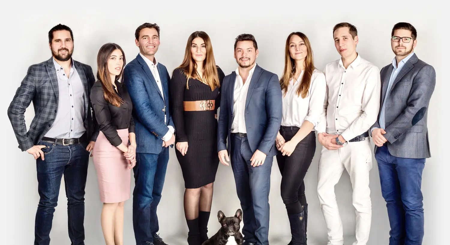 LEE_team GuestLee luxury rental team in formal attire, smiling with a dog, representing Swiss Alps properties in Geneva and beyond. | GuestLee luxury rental Switzerland